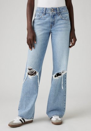 Lichtblauwe, high-waisted, wijde jeans met grote gescheurde delen op de knieën. Gemaakt van denim met een lichte vervaagde textuur.