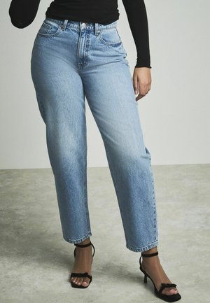 Lichtblauwe high-waisted jeans met een rechte pijp, met een vervaagde textuur, voorzakken en een knoopsluiting. Gepaard met zwarte hakken.