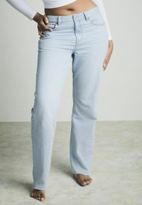Lichtblauwe denim jeans met een rechte pijp, subtiele wassing en een rafelige zoom. Kenmerkt zich door klassieke vijf-pocket styling en een knoopsluiting.