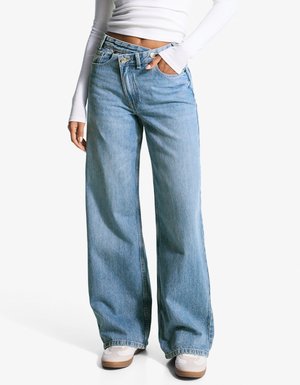Lichtblauwe wijde jeans van denim, met een hoge taille, voorzakken en een relaxte pasvorm. Gestyld met witte sneakers.